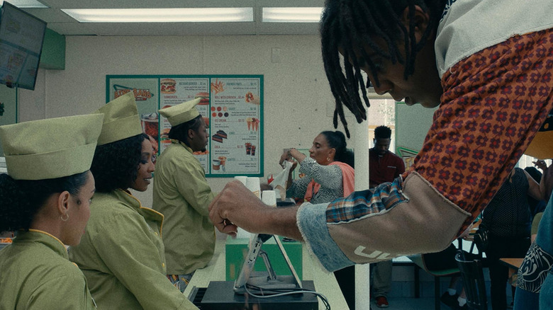 Cootie (Jharrel Jerome) orders from a fast food counter but appears bigger than a normal person in I'm a Virgo