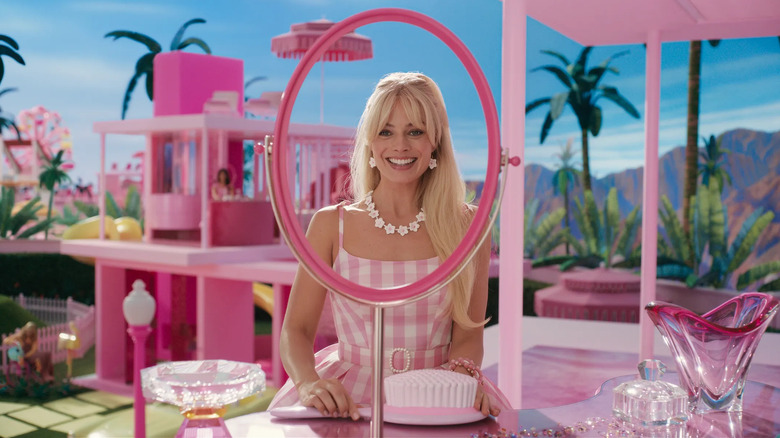 Margot Robbie as Barbie, looking in a mirror in Barbie.