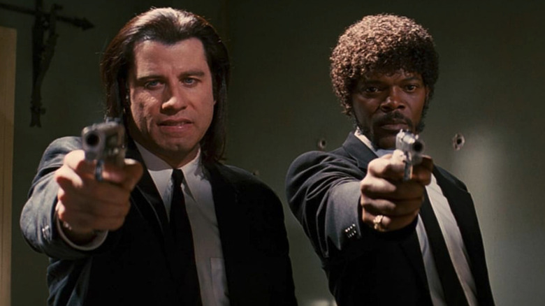 Samuel L. Jackson as Jules Winnfield and John Travolta as Vincent Vega pointing guns in Pulp Fiction.