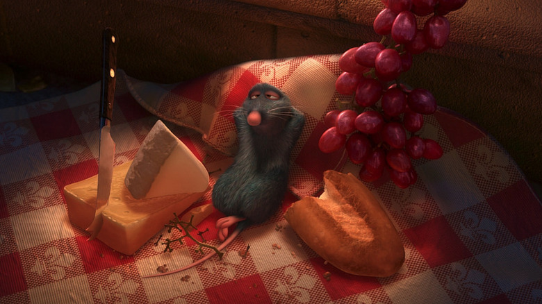 Remy leans back full with food next to partially eaten cheese, grapes, and bread in Ratatouille.