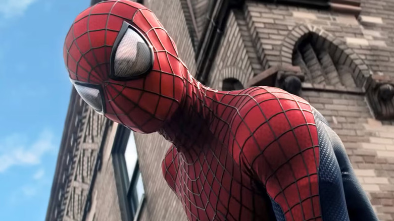 Andrew Garfield as Spider-Man in front of a building in The Amazing Spider-Man 2