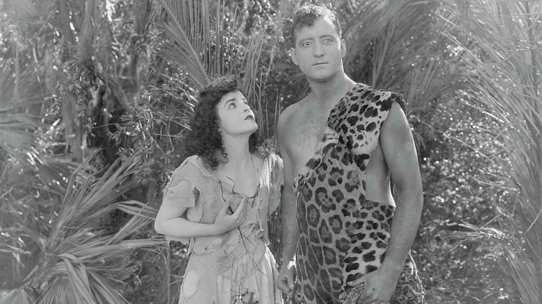 Karla Schramm in raggedy dress as Jane looking up at Gene Pollar wear leopard pelt as Tarzan in The Revenge of Tarzan