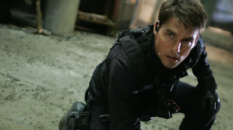 Tom Cruise as Ethan Hunt kneeling in black tactical gear in Mission: Impossible III