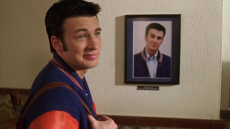 Jake (Chris Evans) smiling by framed photo of himself in Not Another Teen Movie