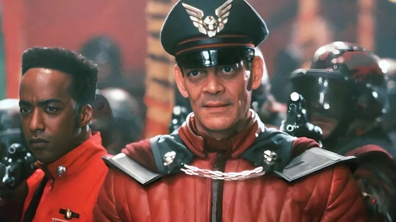 Raul Julia as General Bison stands in front of his minions in Street Fighter