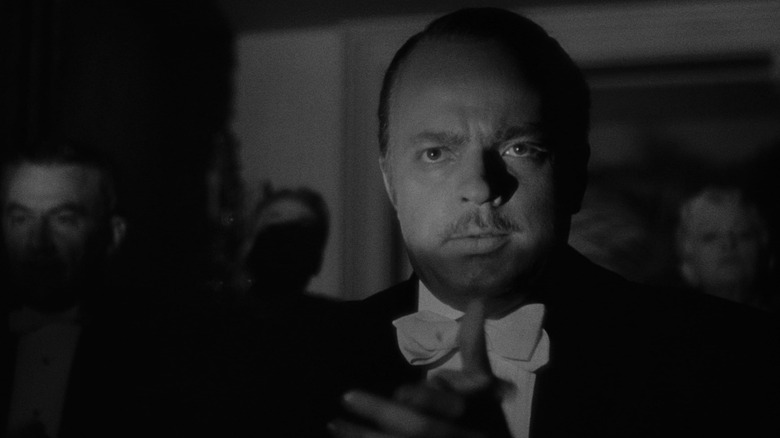 Charles Foster Kane (Orson Welles) applauds his untalented wife in Citizen Kane