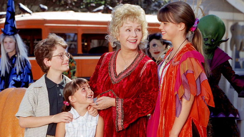 Joey Zimmerman as Dylan, Emily Roeske as Sophie, and Kimberly J. Brown as Marnie stand around Debbie Reynolds as Aggie in Halloweentown