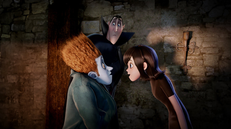Adam Sandler as Dracula watches Andy Samberg as Jonathan and Selena Gomez as Mavis in Hotel Transylvania