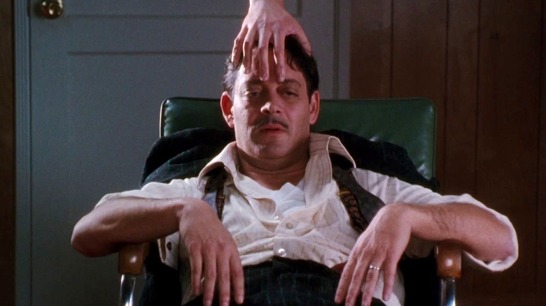 Raul Julia as Gomez Addams gets a massage from Thing in The Addams Family