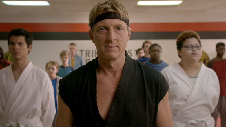 William Zabka as Johnny Lawrence standing with the Cobra Kai students on Cobra Kai
