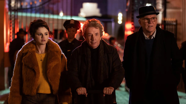 Steve Martin, Martin Short, and Selena Gomez as Charles, Oliver, and Mabel, walking through a court yard with police on Only Murders in the Building