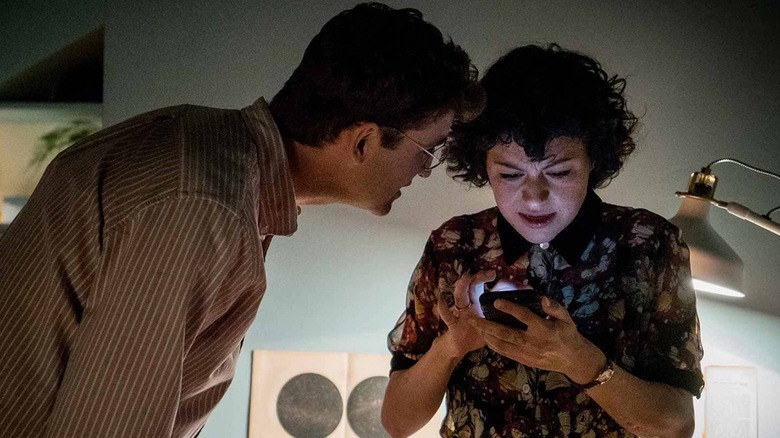 John Reynolds and Alia Shawkat as Drew and Dory looking at a phone on Search Party