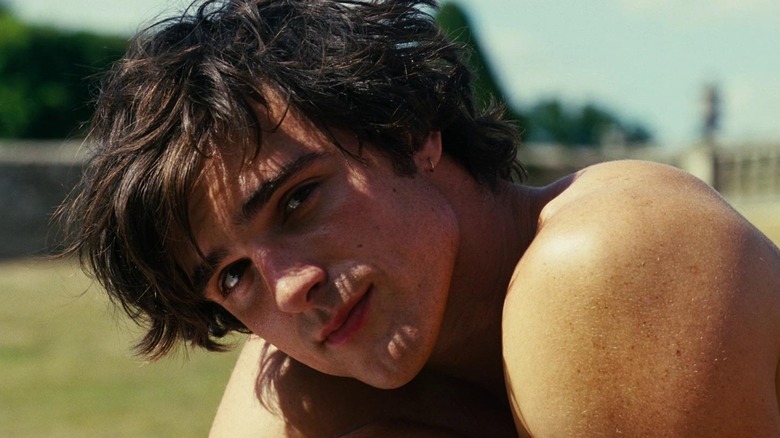 A shirtless Jacob Elordi as Felix in Saltburn, looking into the camera in the sunlight
