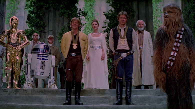C3PO, R2D2, Mark Hamill as Luke Skywalker, Carrie Fisher as Princess Leia, Harrison Ford as Han Solo, and Chewbacca at the medal ceremony at the end of Star Wars: A New Hope