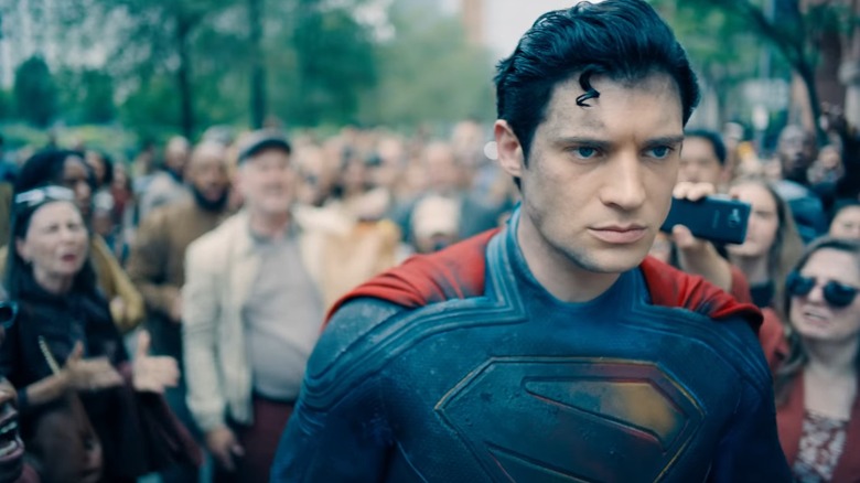 David Corenswet as Superman walking away from an angry crowd in Superman