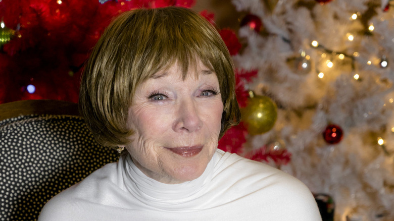 Shirley MacLaine as Pearl smiling by Christmas trees in A Heavenly Christmas