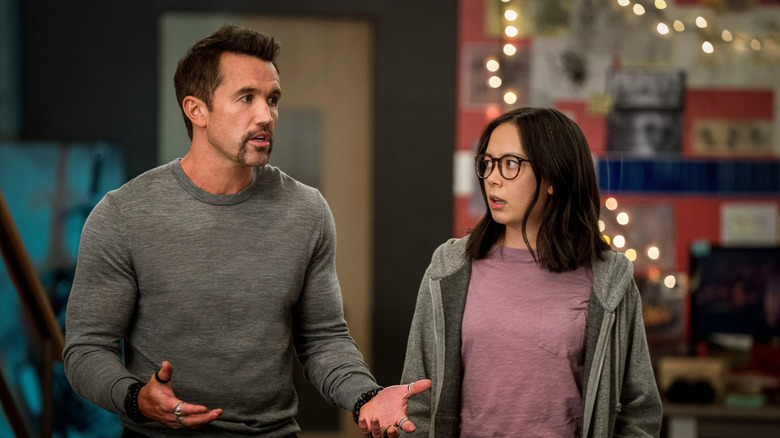 Ian Grimm (Rob McElhenney) explains something animatedly while Poppy Li (Charlotte Nicdao) looks on in Mythic Quest