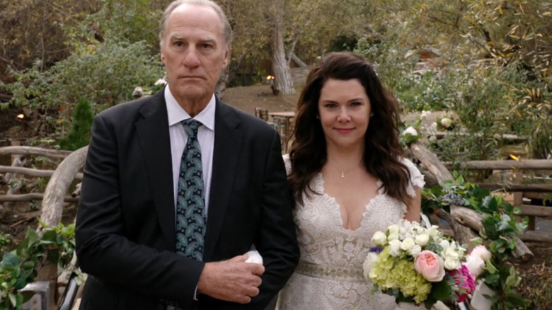 Craig T. Nelson as Zeek in suit walking Lauren Graham as Sarah down the aisle in wedding dress holding flowers in Parenthood