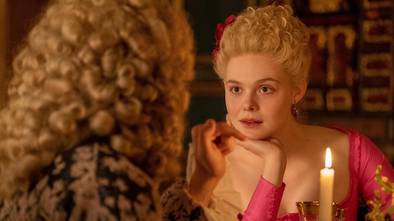 Elle Fanning listens to someone in a wig