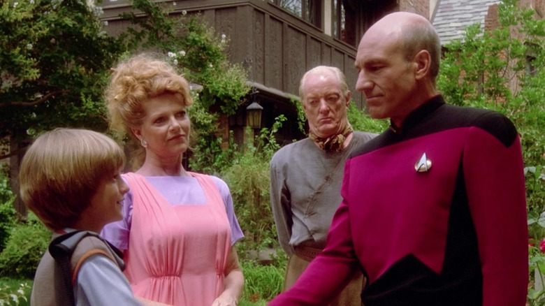 Jean-Luc Picard (Patrick Stewart) shakes hands with René (David Tristan Birkin) as Marie (Samantha Eggar) and Robert (Jeremy Kemp) watch in Star Trek: The Next Generation