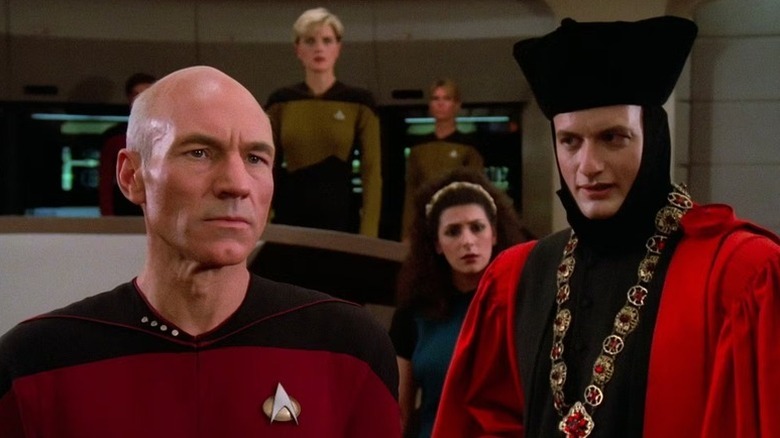 Jean-Luc Picard (Patrick Stewart) stares intently as Q (John de Lancie) speaks to him in Star Trek: The Next Generation