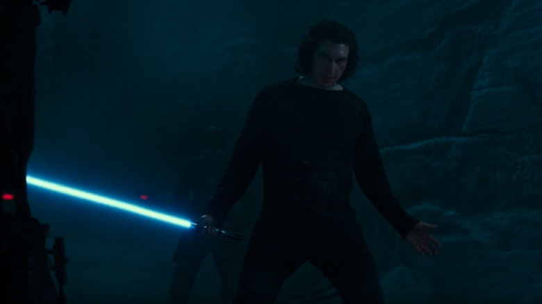 Ben Solo (Adam Driver) defiantly holds a blue lightsaber before the Knights of Ren in Star Wars: The Rise of Skywalker