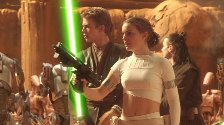 Hayden Christensen as Anakin Skywalker holds his lightsaber next to Natalie Portman as Padme Amidala in Star Wars: Episode II - Attack of the Clones