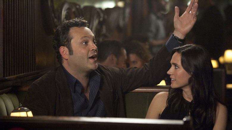 Vince Vaughn as Ronny Valentine raises his hand next to Jennifer Connelly as Beth in the Dilemma
