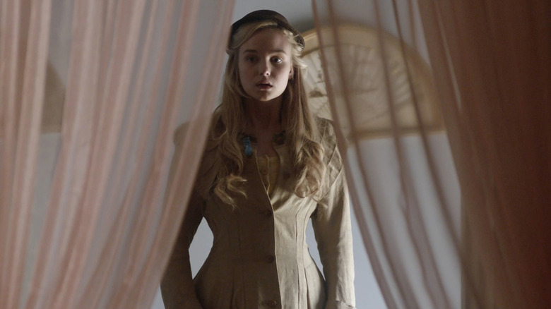 Denise (Joanna Vanderham) looking through gauzy drapes in The Paradise