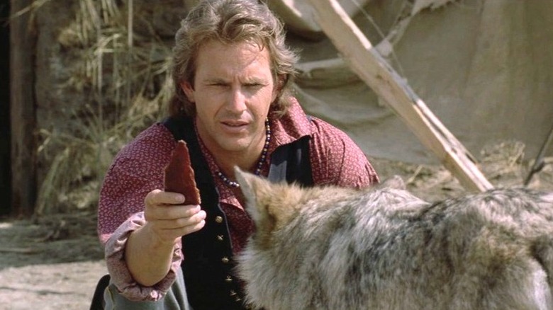 John Dunbar (Kevin Costner) offers a piece of meat to a wolf in Dances with Wolves