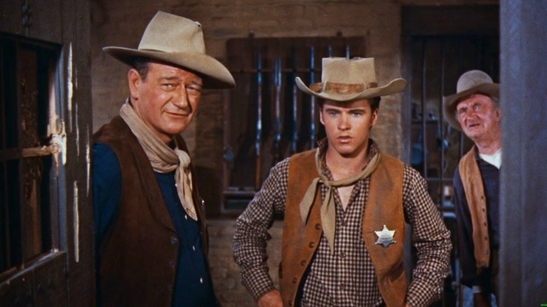 John T. Chance (John Wayne), Colorado Ryan (Ricky Nelson), and Stumpy (Walter Brennan) glance out of a jail in Rio Bravo