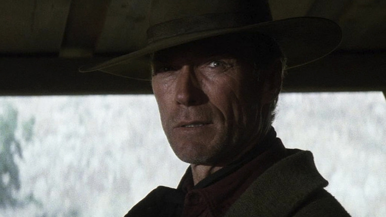 Will Munny (Clint Eastwood) stands confidently in a doorway in Unforgiven (1992)
