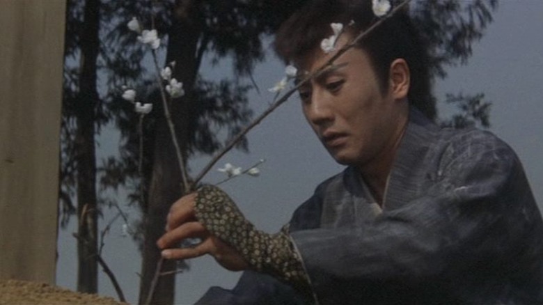 Shingo Takakura placing flowers on a grave