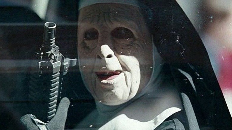The Town - Doug holding assault rifle, riding in back of car disguised as nun