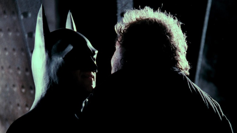 Michael Keaton's Batman holds a thug close to his face in Batman