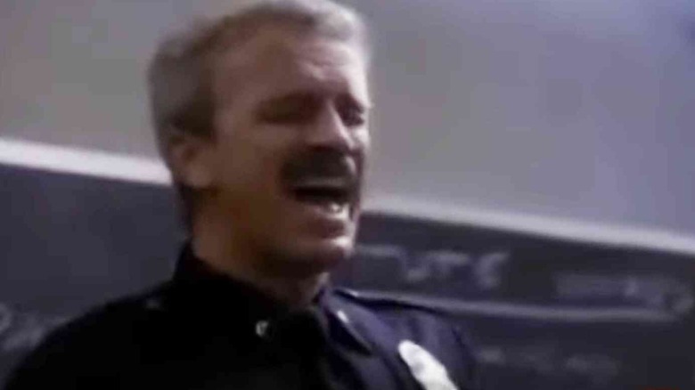 A cop, singing, a scene from Cop Rock.