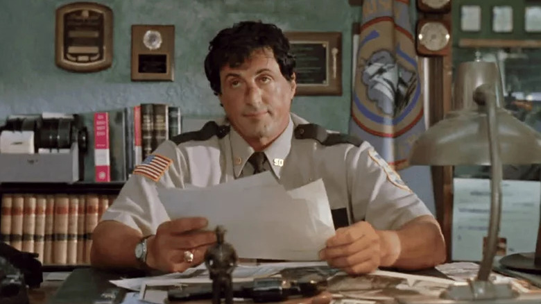 A bemused Freddy Heflin (Sylvester Stallone) sits at his desk in Cop Land