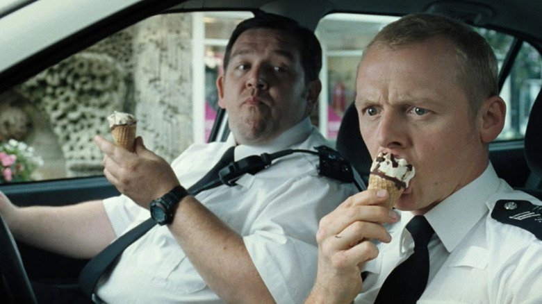 Nicholas Angel (Simon Pegg) thoughtfully eats an ice cream cone as Danny Butterman (Nick Frost) watches in Hot Fuzz