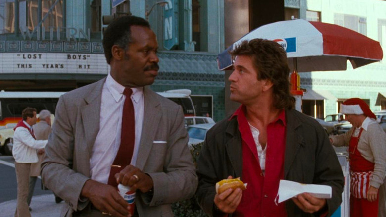 Martin Riggs (Mel Gibson) eats a hot dog while speaking to Roger Murtaugh (Danny Glover) in Lethal Weapon