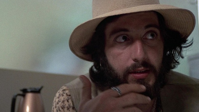 Frank Serpico (Al Pacino) thoughtfully rubs his beard in Serpico