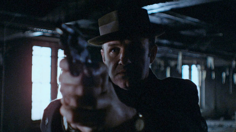 Popeye Doyle (Gene Hackman) points a gun in an abandoned building in The French Connection