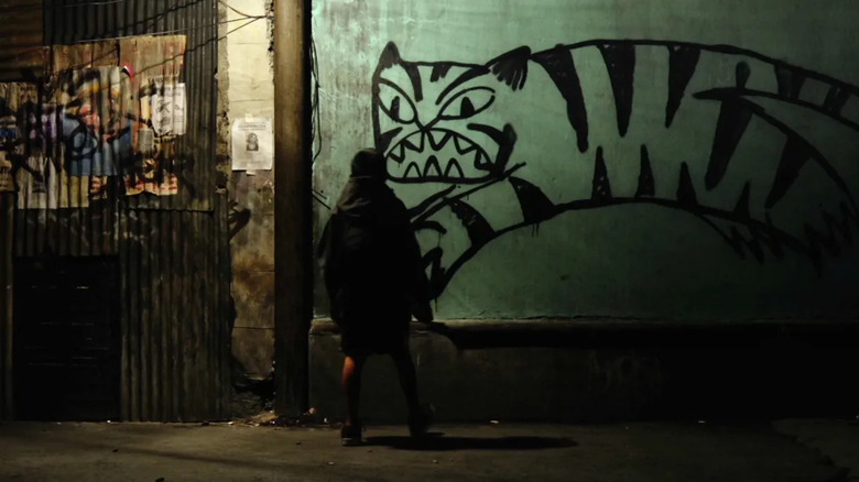 Girl looking at street graffiti of tiger