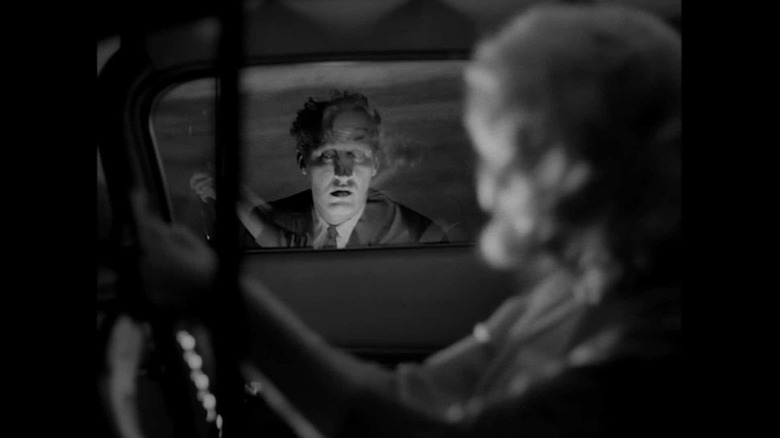 Woman driving with creepy man appearing outside window