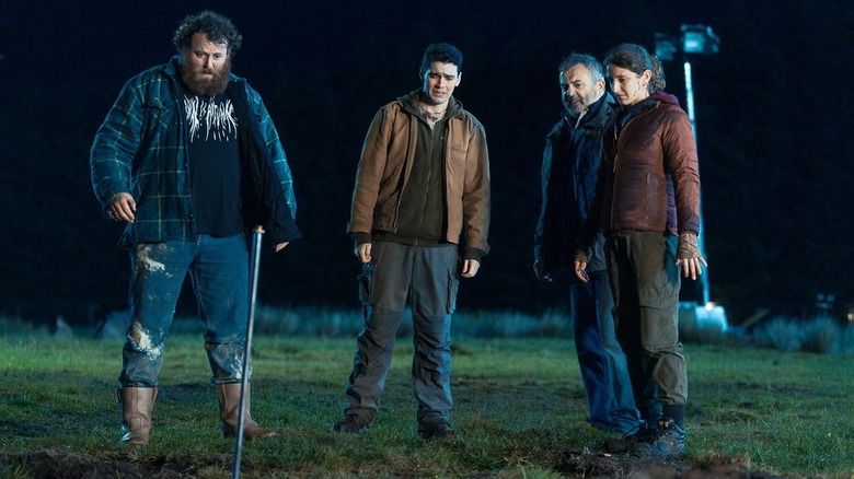 Four friends stand horrified in field