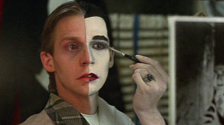 Man applying makeup to look like Dracula