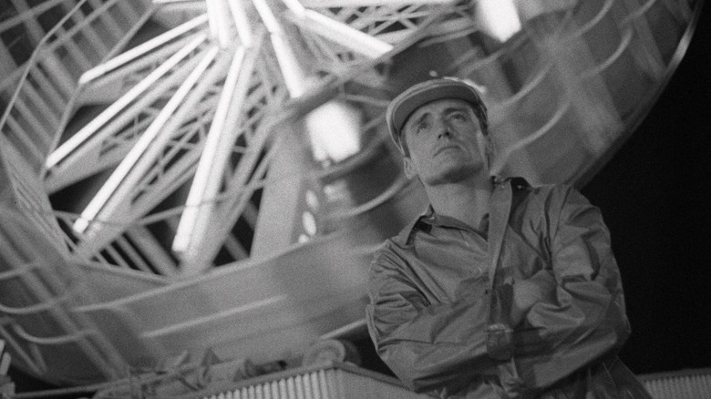 Man stands in front of ferris wheel