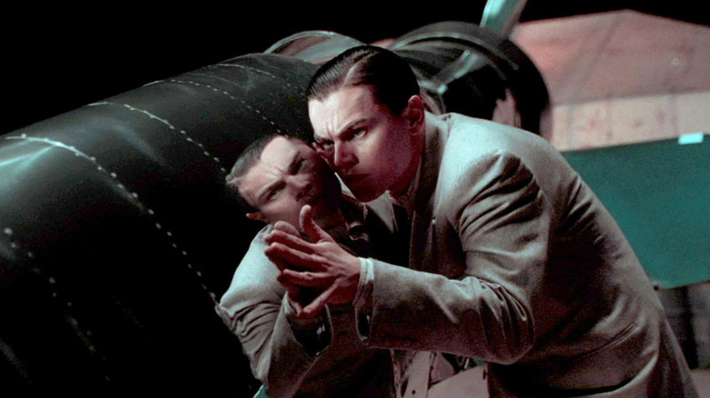 Howard Hughes (Leonardo DiCaprio) feels the smooth, metal surface of a new plane in The Aviator