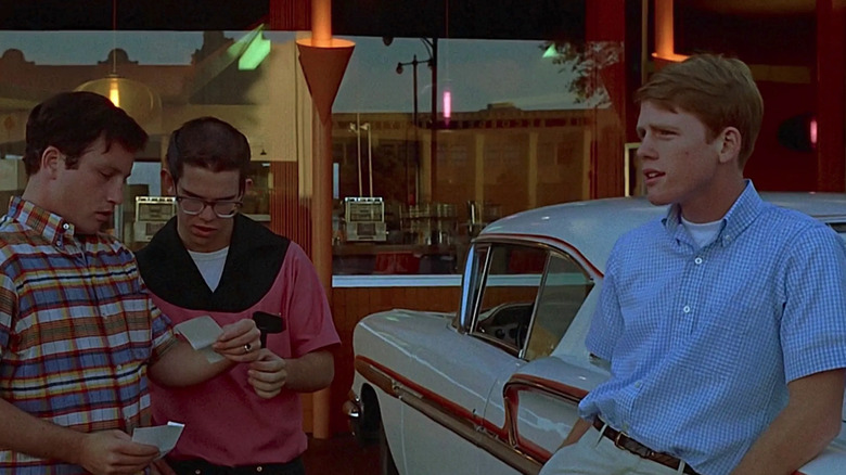 Curt (Richard Dreyfuss), Terry (Charles Martin Smith), and Steve (Ron Howard) hang outside Mel's Drive-In in American Graffiti