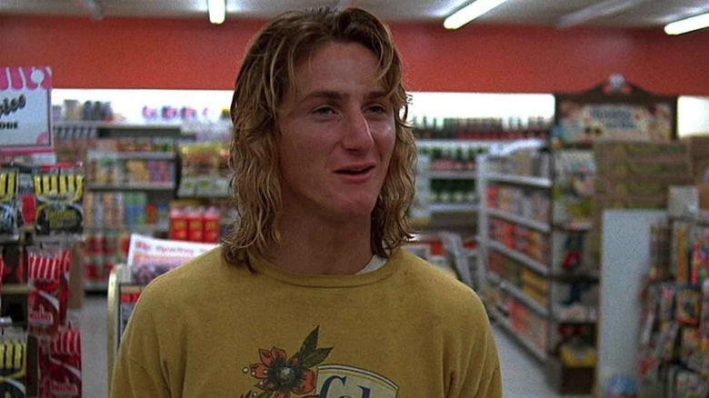 Sean Penn as Jeff Spicoli in a convenience store in Fast Times at Ridgemont High, standing in a convenient store in a green shirt with a Colt 45 can on it.