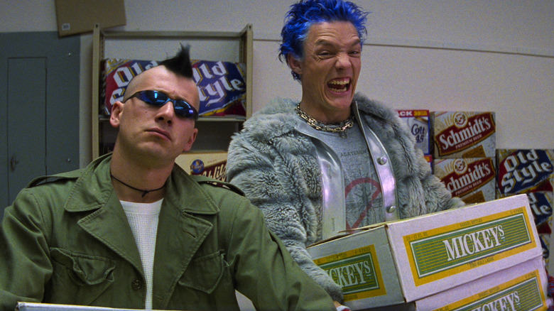 Matthew Lillard and Michael A. Goorjian as Stevo and Bob, carrying some beer in the liquor store in SLC Punk. Lillard is bearing his teeth and Goorjian is wearing sunglasses and looking straight-faced.